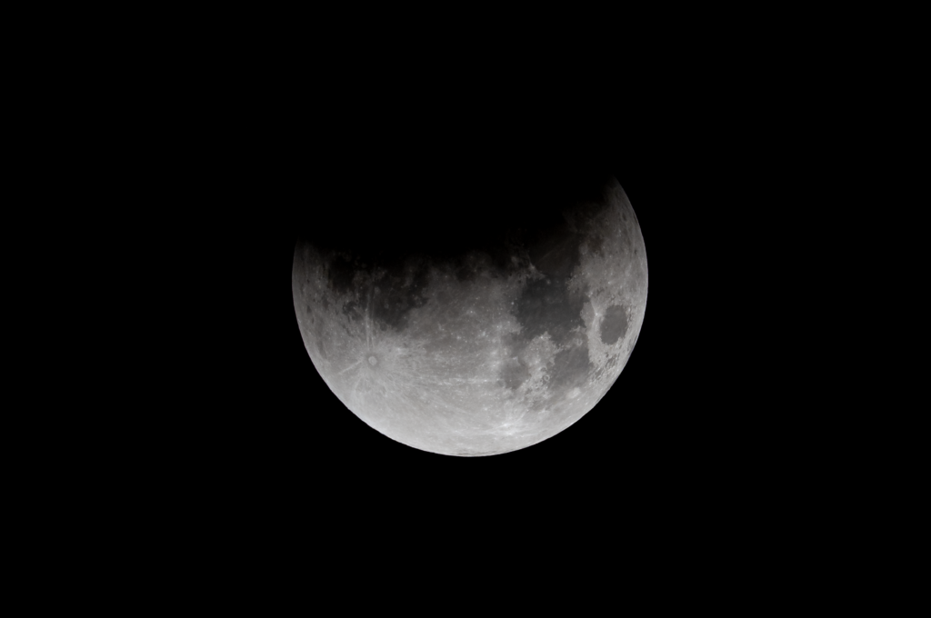 artial lunar eclipse with Earth's shadow moving across the Moon